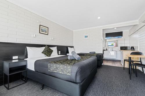 a hotel room with a bed and a couch at Anchor Wheel Motel in St Helens
