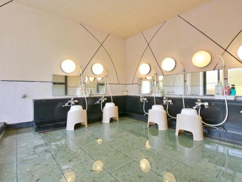 a bathroom with four sinks and a row of mirrors at おばな旅館 富貴亭 in Nagano