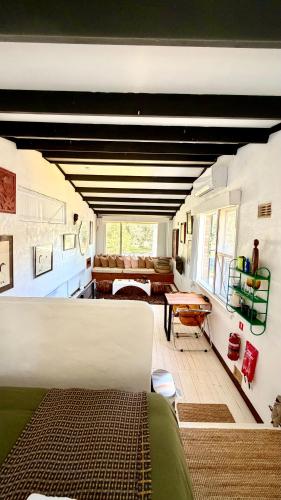 a room with a bed and a living room at MELLOW TREES Lake front studio with sauna in Budgewoi