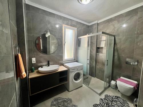 a bathroom with a sink and a washing machine at Dalyan Villa in Dalyan