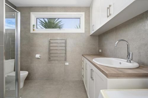a bathroom with a sink and a toilet and a window at My Place, McCrae in McCrae