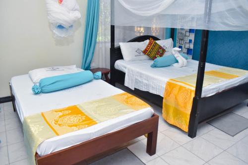 two beds in a room with two at Swahili Social House in Mombasa
