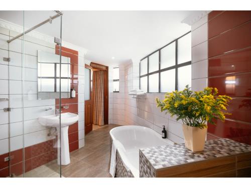 a bathroom with a tub and a toilet and a sink at Karen Plains Hotel Nairobi in Nairobi