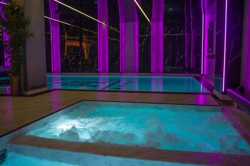 ein Whirlpool in einem Raum mit violetter Beleuchtung in der Unterkunft Hotel Lantier - Basen & Gabinet SPA in Bytom