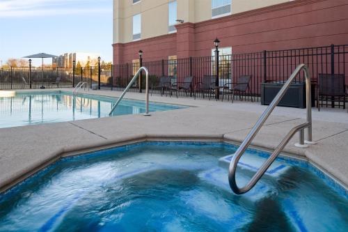 a small swimming pool with metal hand rails next to a building at Hampton Inn Augusta Fort Eisenhower in Augusta