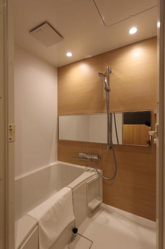 a bathroom with a bath tub and a sink at 虎屋旅館 in Kotohira