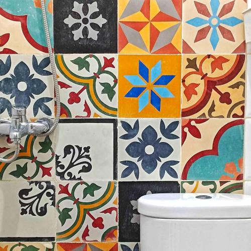 a bathroom with a toilet and a colorful tile wall at Sabi House Danu, Family Home near Prawirotaman in Timuran
