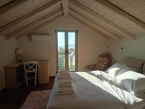 a bedroom with a bed and a desk and a window at ALONI retreat in Proástion