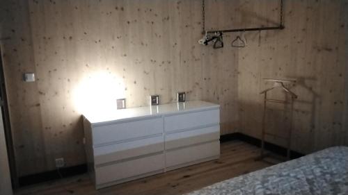 a bedroom with a white dresser with a light on it at Le grenier in Bazas