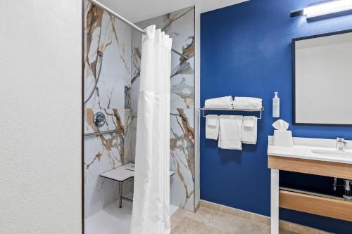 a bathroom with a shower and a sink at Spark by Hilton Shawnee in Shawnee