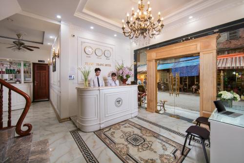 a man and a woman standing at a counter in a salon at Hanoi TrangTrang Hotel in Hanoi