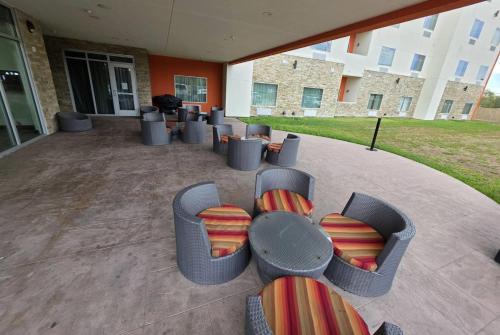 a group of chairs and tables in front of a building at Hawthorn Extended Stay by Wyndham Corpus Christi I-37 NW in Corpus Christi
