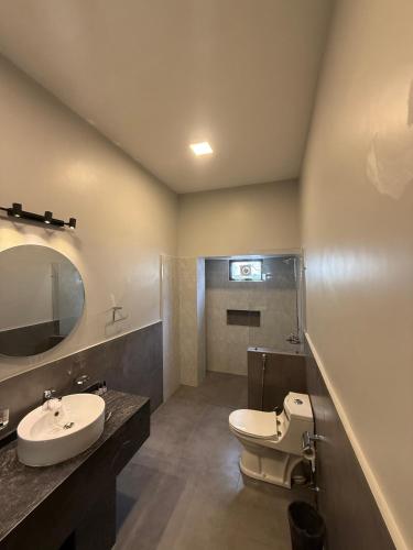 a bathroom with a white toilet and a sink at Ghumo - 10BR Villa in Bahadurabad near Aga Khan in Karachi