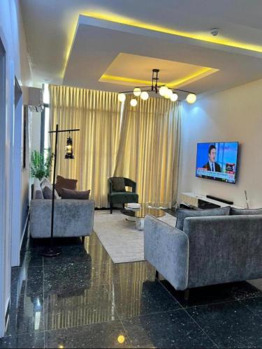 a living room with couches and a flat screen tv at Paradise View Apartment in Gatunga