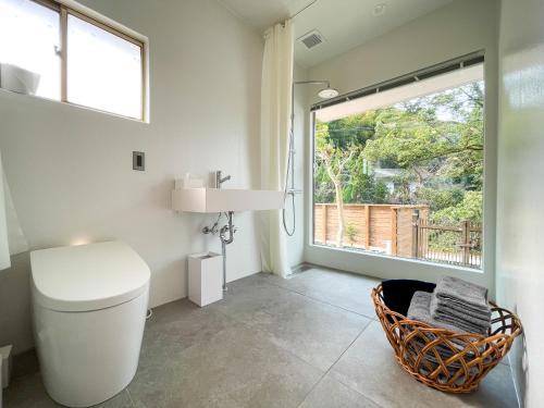 a bathroom with a toilet and a window at Beppu TOJIHAUS 001 2min walk to Shibaseki Onsen in Beppu