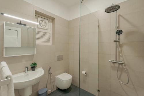 a bathroom with a shower and a toilet and a sink at Mulberry Living in Negombo