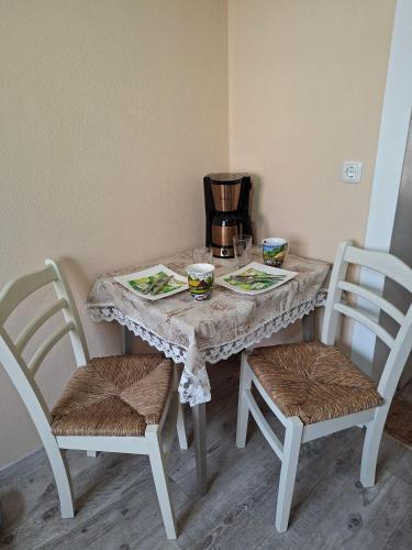 a table with two chairs and a table with plates and drinks at Ellens Farm in Kolkwitz