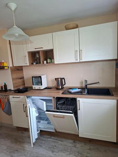 a kitchen with white cabinets and a sink at Ellens Farm in Kolkwitz