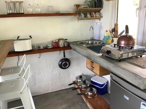 a kitchen with a counter with a sink and a stove at Studio Ti Lakaz lao in Petit Brûlé