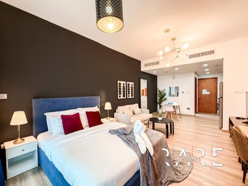 a bedroom with a large bed and a living room at Rare Holiday Homes - Crescent Tower - IMPZ - Dubai Production City - R704 in Dubai
