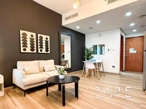 a living room with a couch and a table at Rare Holiday Homes - Crescent Tower - IMPZ - Dubai Production City - R704 in Dubai