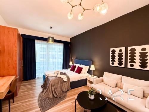 a bedroom with a bed and a couch at Rare Holiday Homes - Crescent Tower - IMPZ - Dubai Production City - R704 in Dubai