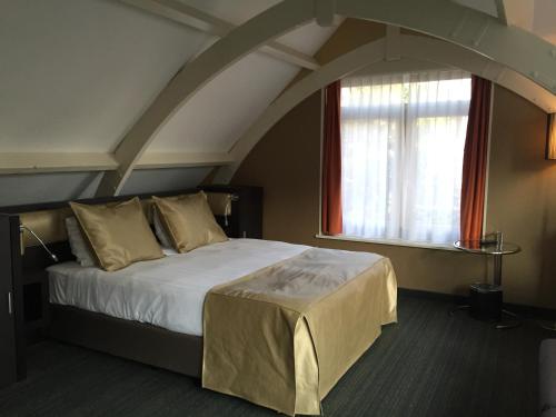 a bedroom with a large bed with a window at Golden Mansion Aparthotel in Amsterdam