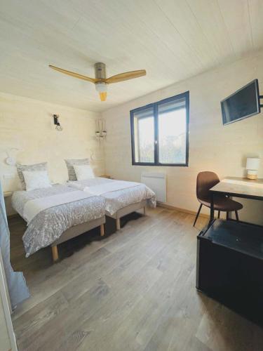 a bedroom with a large bed and a desk at L'Océane Bed&Breakfast in Lacanau-Océan