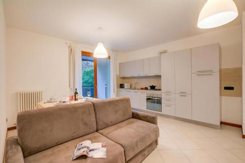 a living room with a couch and a kitchen at Magnolia: Laveno Centre 2BR with Terrace - Happy Rentals in Laveno-Mombello