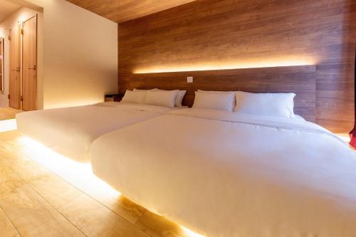 a large white bed in a bedroom with lights at Gouhou Garden Hotel Asakusa in Tokyo