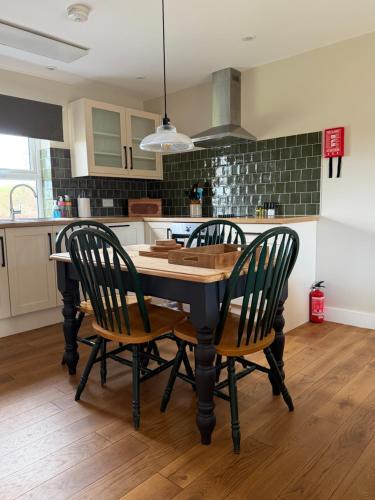 a kitchen with a table and chairs in a room at The Old Garage in Rural Northumberland in Edlingham