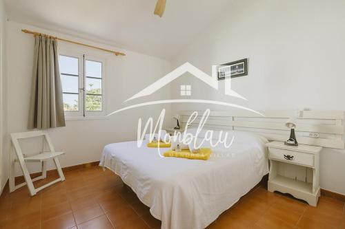 a bedroom with a bed with a house on the wall at Sa Torreta 4 in Cala Blanca