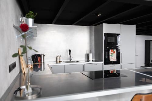 a white kitchen with a sink and a refrigerator at Chaya Niwas Loft in Żyrardów