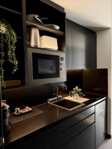 a kitchen with a sink and a microwave at Spice On Broadway in Sydney