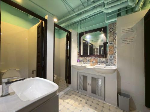 a bathroom with two sinks and a mirror at Merge Hostel Chinatown in Samphanthawong