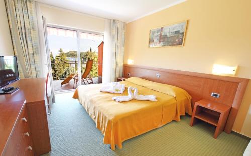 a hotel room with a bed with towels on it at Bioenergy Resort Salinera Hotel in Strunjan