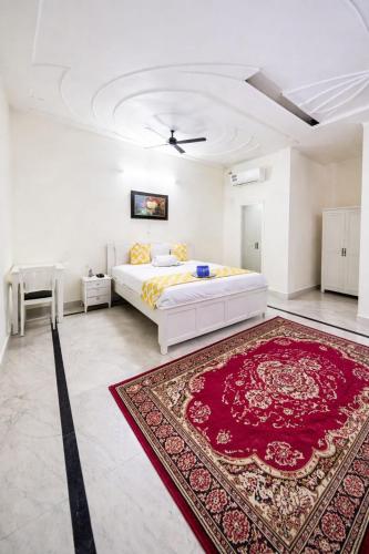 a bedroom with a white bed and a red rug at Hotel Roselle Heights in Jaipur