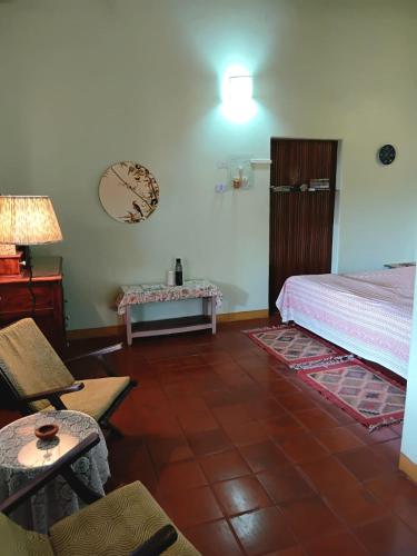 a bedroom with a bed and a table and a chair at Shantidarshan Homestay in  Amboli 