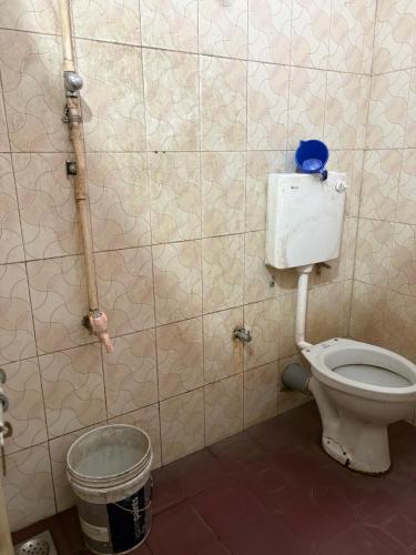 a bathroom with a toilet and a trash can at Star Hostel in Kannur