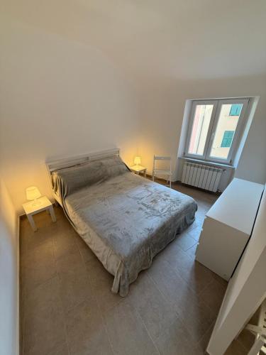 ein Schlafzimmer mit einem großen Bett und zwei Fenstern in der Unterkunft Cielo in Mele