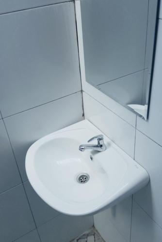a white sink in a bathroom with a mirror at El-Mindri Bungalow dan Resto in Gili Gede
