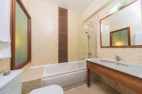 a bathroom with a tub and a sink and a mirror at Sunbay Park Hotel in Marmaris