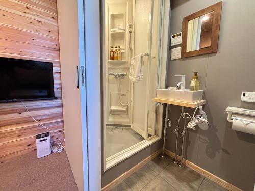 a bathroom with a shower and a sink at NikkaHotel東郷店 in Togo