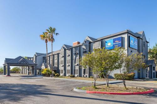 a building with palm trees in a parking lot at Baymont by Wyndham San Antonio Downtown in San Antonio