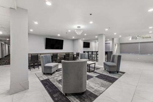 a waiting room with chairs and a table and a tv at Baymont by Wyndham San Antonio Downtown in San Antonio
