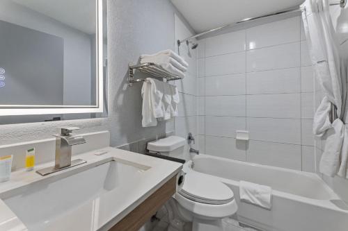 a white bathroom with a sink and a toilet at Baymont by Wyndham San Antonio Downtown in San Antonio