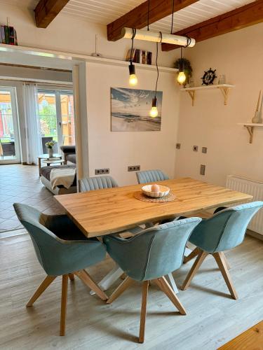 a dining room with a wooden table and chairs at Ferienhaus Schlummerkoje in Friedrichskoog