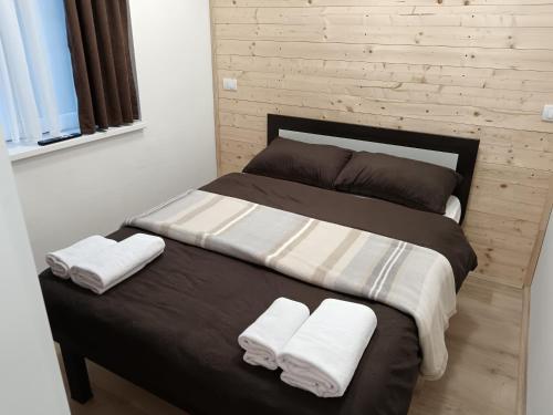 un letto con due cuscini e asciugamani sopra di MiM LUX a Gornji Milanovac