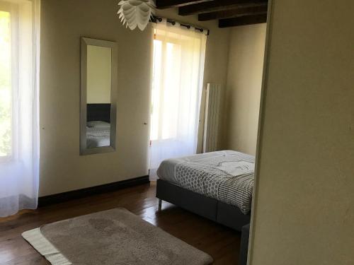 a bedroom with a bed and a mirror on the wall at Grande maison entre vert et bleu in Saint-Yrieix-la-Montagne