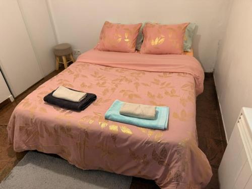 a bedroom with a bed with two towels on it at Bartholomé LE MAGNIFIQUE in Drancy